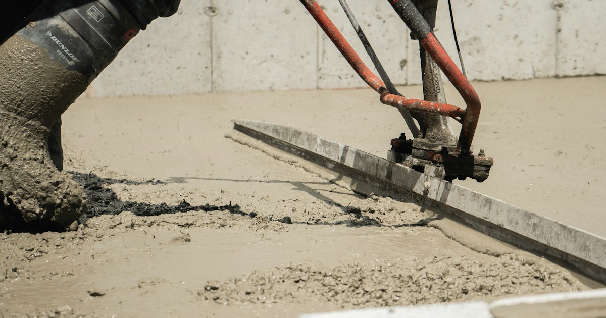 Concrete finishing machine smoothing wet concrete on a freshly poured slab at a construction site